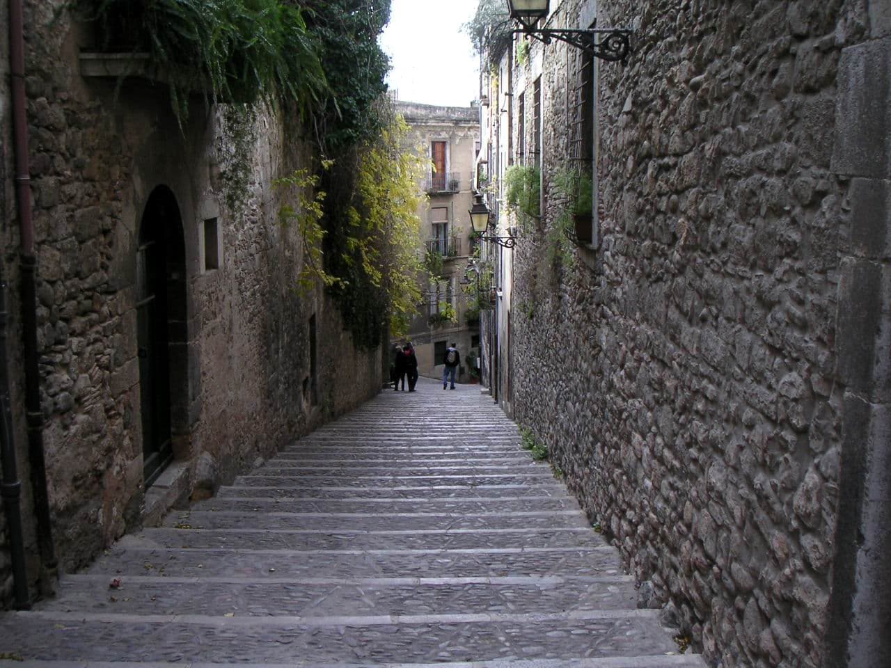 Callejón de piedra estrecho y empedrado con escaleras en El Call, el barrio judío medieval de Girona