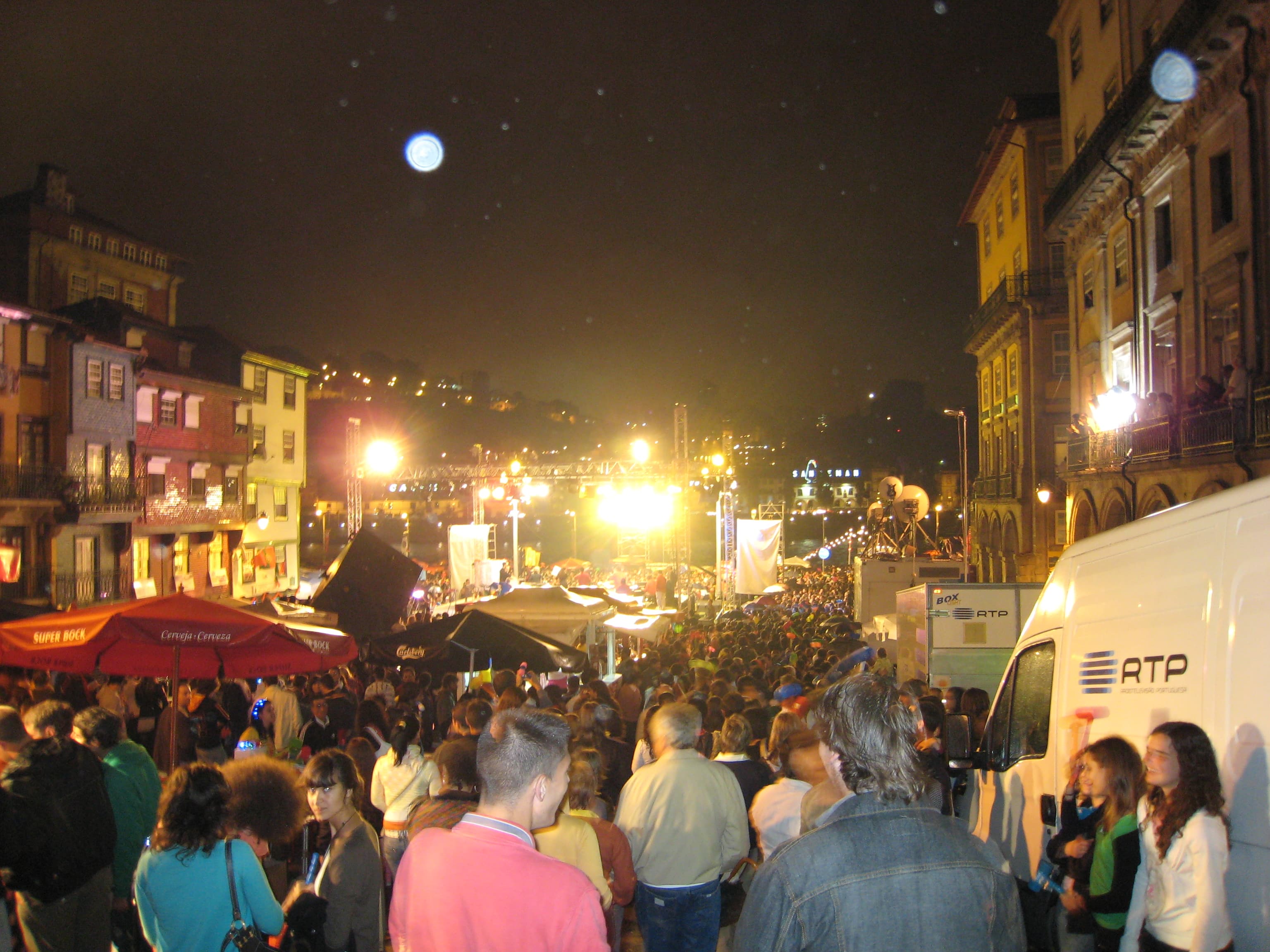 Multitud celebrando la Festa de São João en las calles de Porto de noche