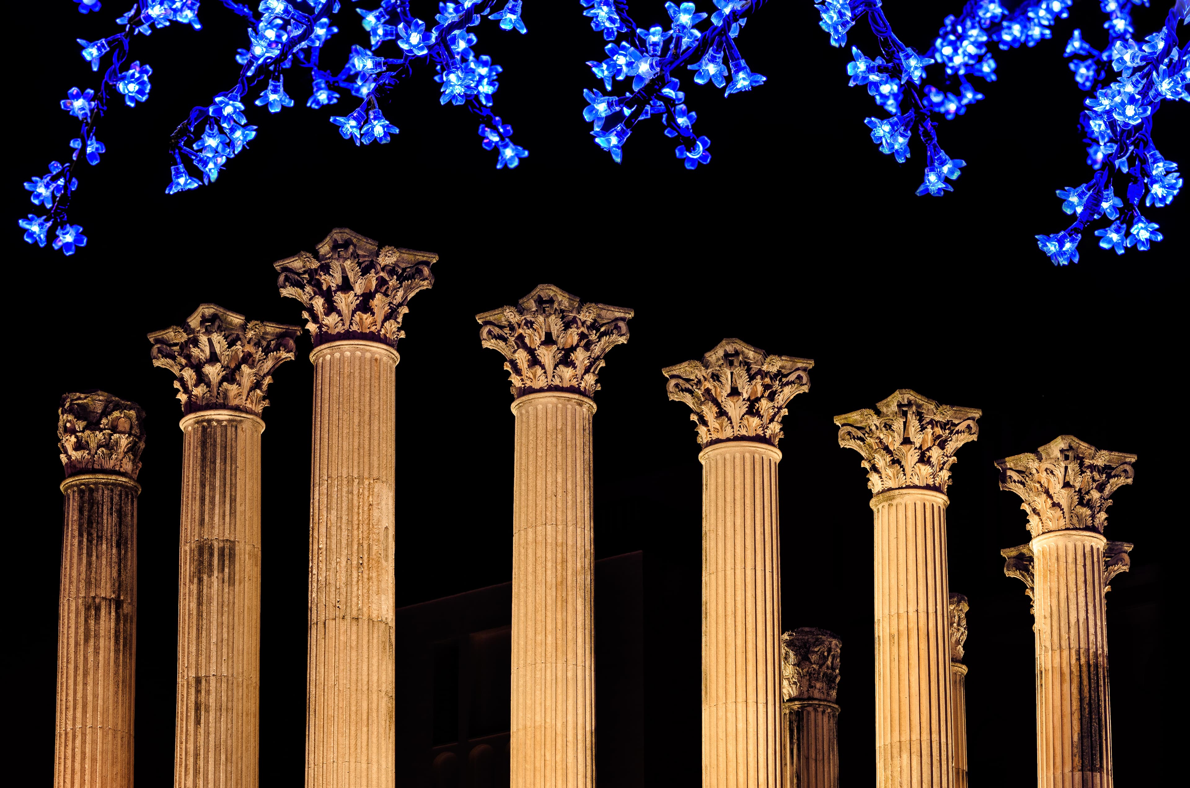 Columnas del templo romano de Córdoba iluminadas con decoración navideña por la noche