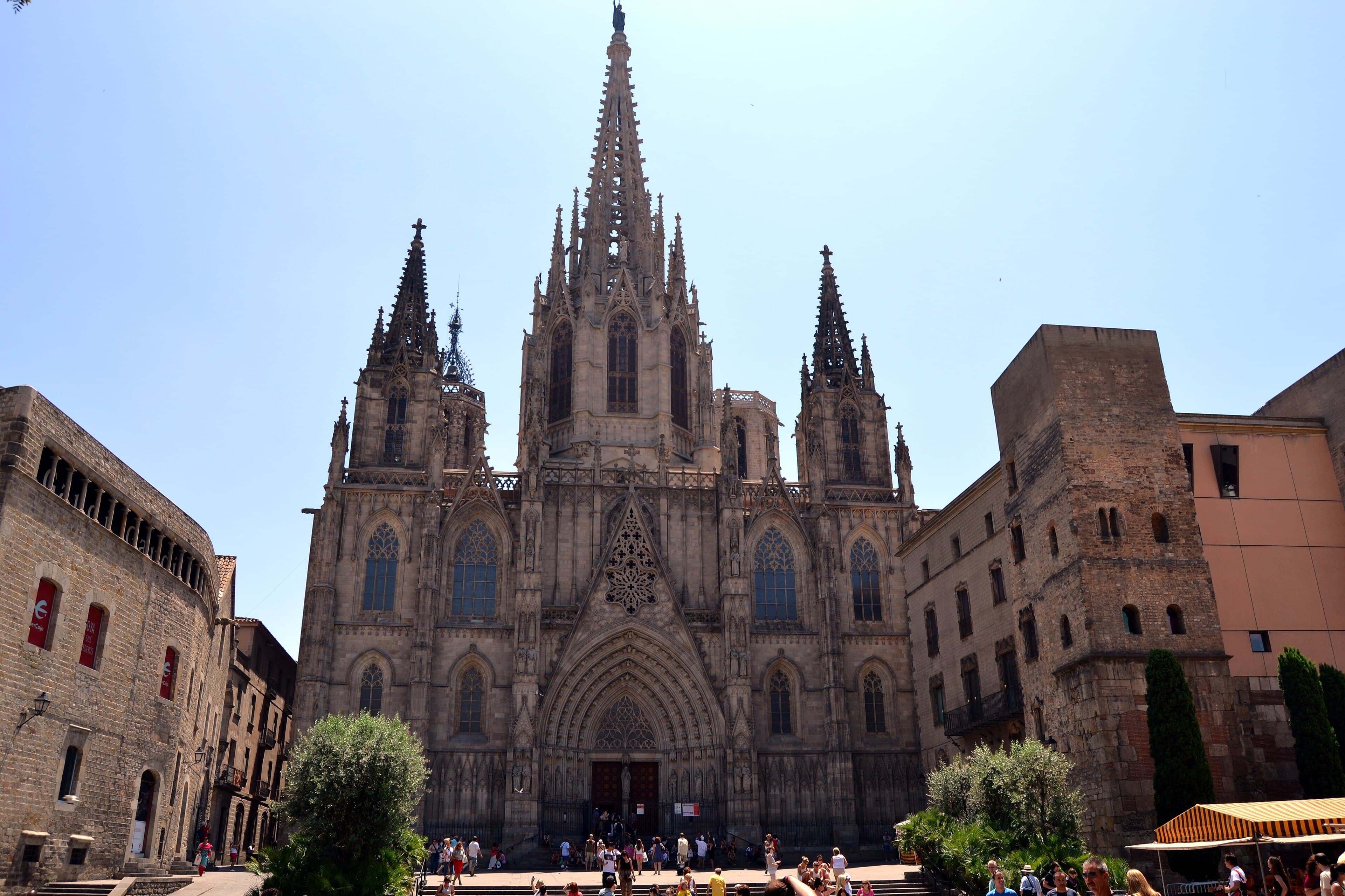 La fachada gótica de la catedral de Barcelona, en el corazón del Barri Gòtic, con sus pináculos y la torre central elevándose sobre la plaza